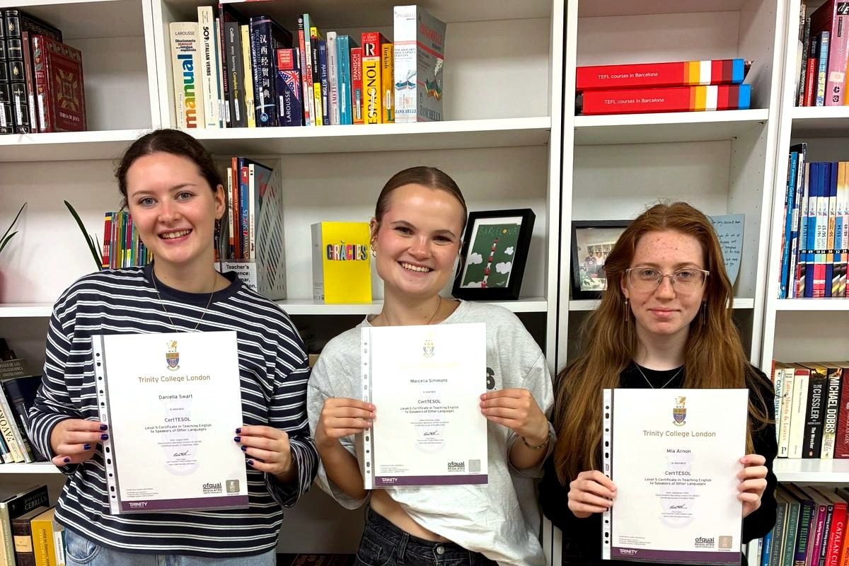 Three graduates holding their Trinity CertTESOL certificates in the TEFL Iberia library