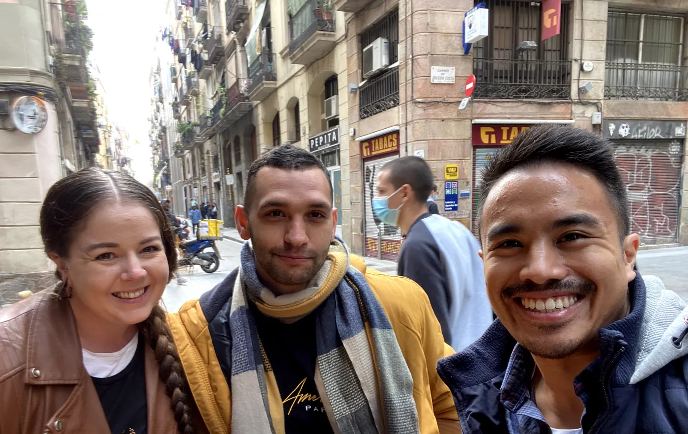 Three friends smiling for a selfie on a street in Barcelona’s old town